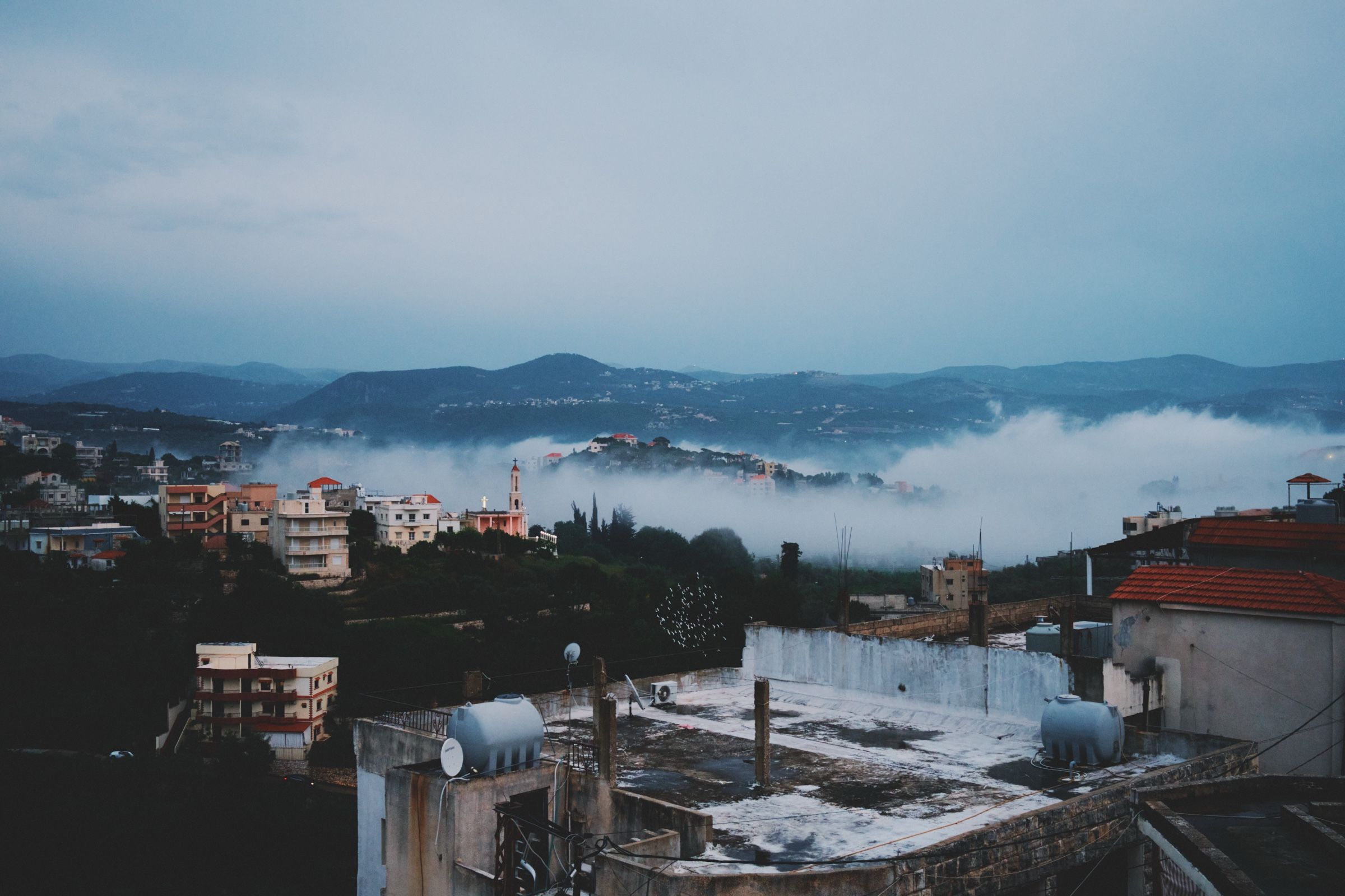 A view of Joun on a foggy evening, seen from one of the village rooftops. The town of Joun, Lebanon, 2024.